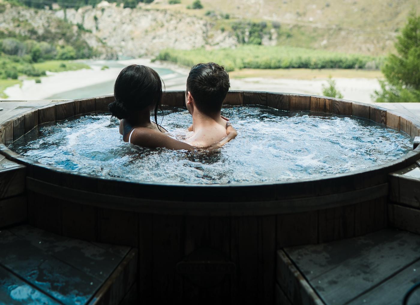 a couple in an outdoor hot tub looking at nature